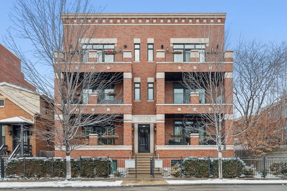Front view of a multi-story brick building with balconies.