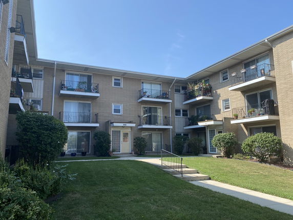 Front view of a three-story apartment building with balconies.
