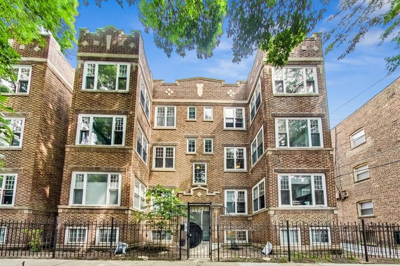 Front view of a multi-story brick building with multiple windows.