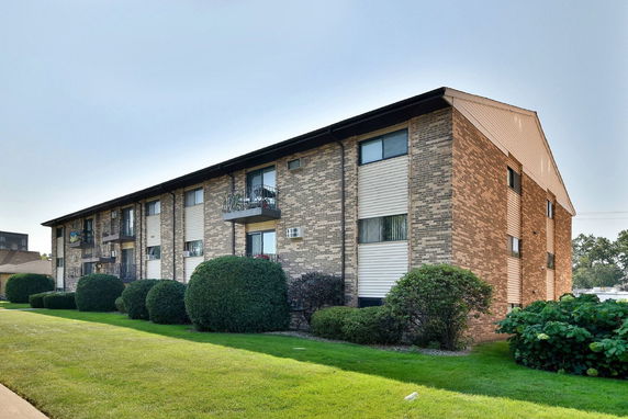 Front view of a multi-story apartment building with brick exterior.