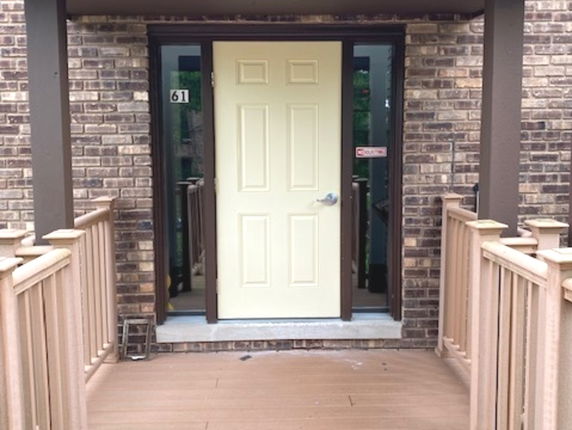 Front entrance of a brick house with a yellow door.