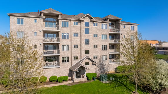 Front view of a multi-story apartment building with balconies.