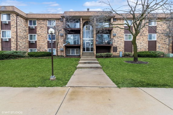 Front view of a multi-story brick apartment building.