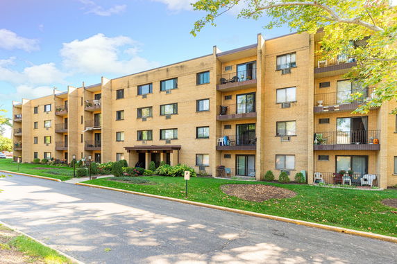 Front view of a multi-story apartment building with balconies.