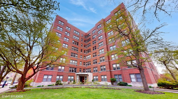 Front view of a multi-story brick building with numerous windows and a central entrance.