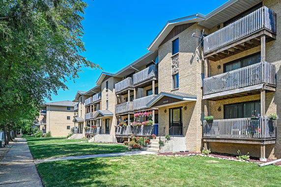 Front view of a multi-story apartment building with balconies.