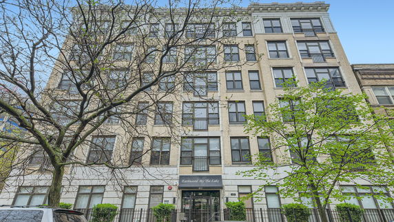 Front view of a multi-story residential building with large windows.
