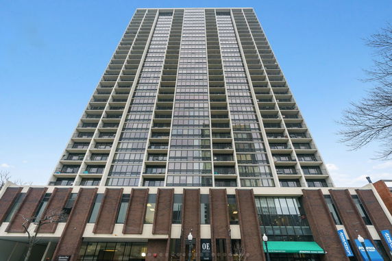 Front view of a tall high-rise building with multiple balconies and large windows.