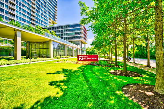 Front view of a modern multi-story building with large glass windows.