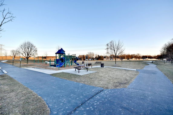 Playground with slides and benches in a park setting