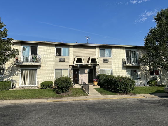 Front view of a two-story apartment building with balconies.