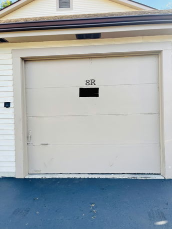 Front view of a garage with a beige door marked with 8R.