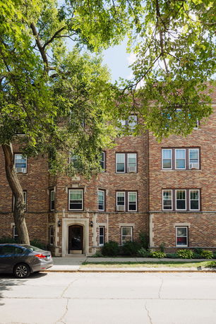 Front view of a multi-story brick apartment building.