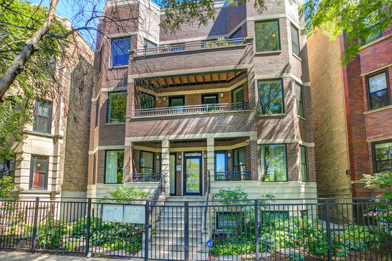 Front view of a multi-story brick building with balconies.