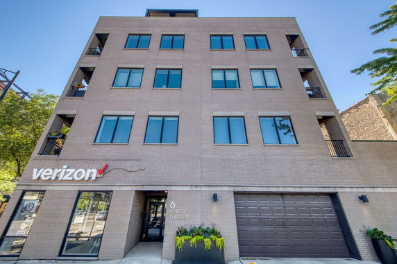Front view of a multi-story office building with several windows and a garage.