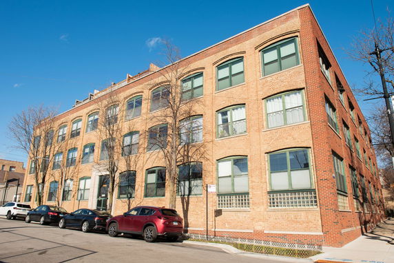 Front view of a three-story brick building with multiple windows.