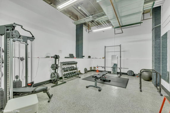 Indoor gym area with weightlifting equipment and machines.