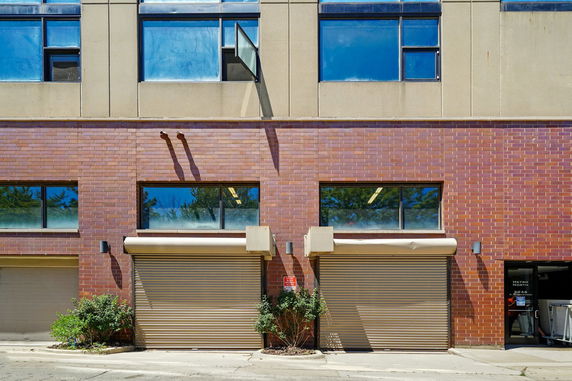 Front view of a building with brick facade and roller doors.