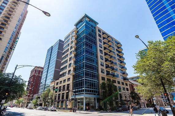 Front view of a multi-story urban building with balconies and glass facade.