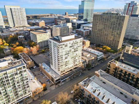 Aerial view of multiple high-rise buildings in a cityscape near a body of water.