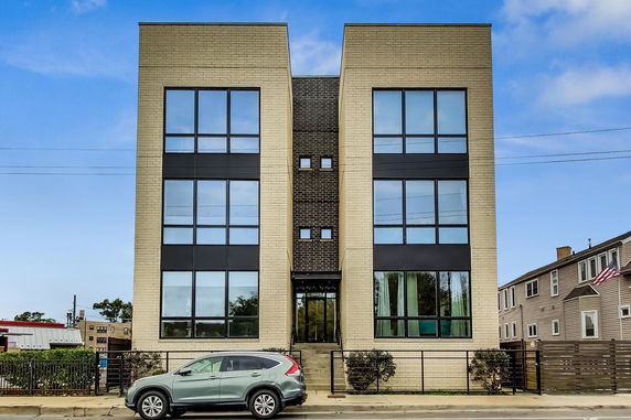 Front view of a modern three-story building with large windows.