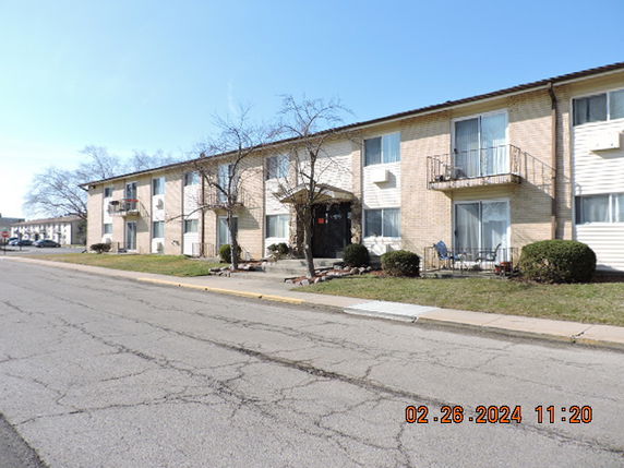 Front view of a two-story apartment building with balconies.