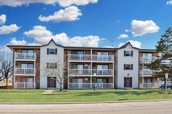 Front view of a multi-story apartment building with balconies.