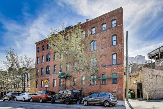 Front view of a multi-story brick building with arched windows.