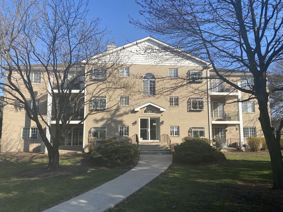 Front view of a multi-story apartment building with balconies.