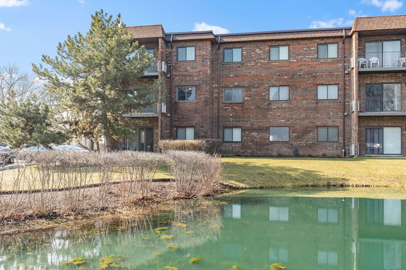 Front view of a brick apartment building with multiple balconies.
