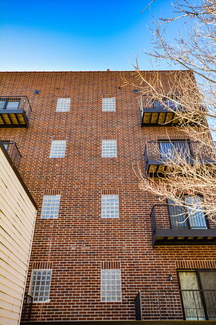 Front view of a multi-story brick building with balconies.