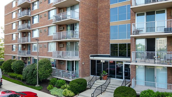 Front view of a multi-story apartment building with balconies.