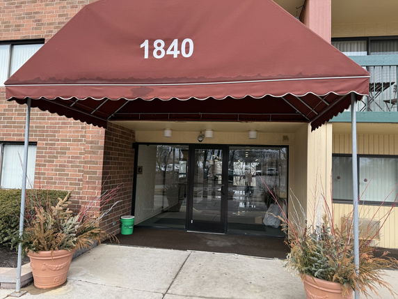 Front entrance of a building with a red canopy labeled 1840.