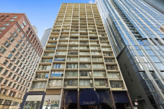 Front view of a tall apartment building with multiple balconies.