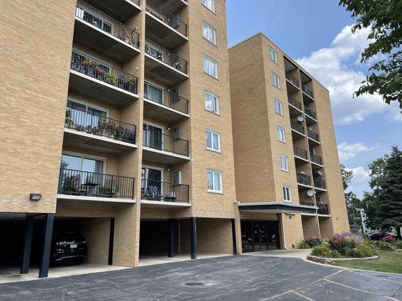 Front view of a multi-story apartment building with balconies.