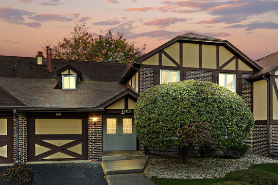Front view of a house with an attached garage and Tudor-style design.