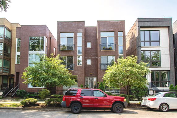 Front view of a modern multi-story brick apartment building.