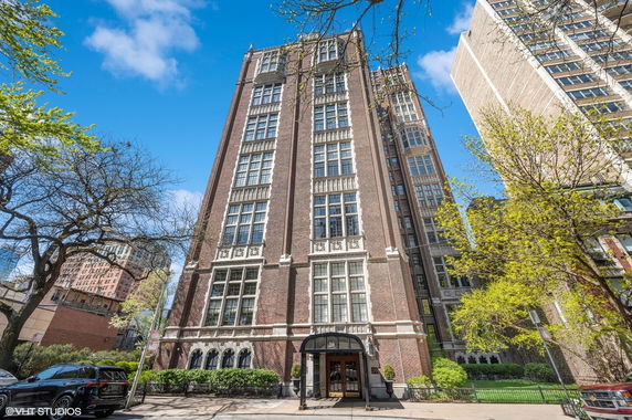 Front view of a multi-story brick building with large windows.