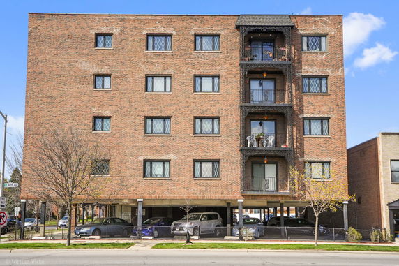 Front view of a multi-story brick building with balconies.
