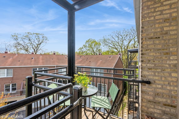 View from a balcony overlooking neighboring residential buildings with brick exteriors.
