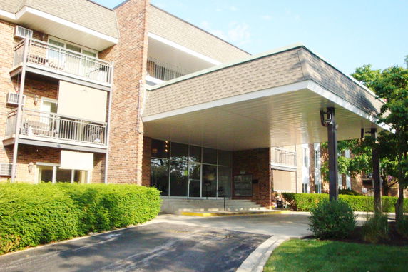 Front view of a multi-story brick building with a covered entrance.