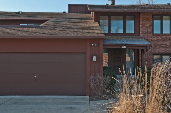 Front view of a two-story house with a brick facade and a garage.