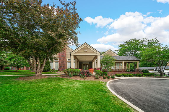 Front view of a building with a covered entrance and brick accents.