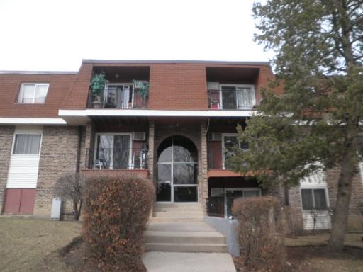 Front view of a three-story apartment building with balconies.