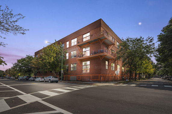 Front view of a multi-story brick building with balconies.