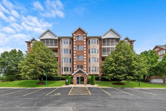 Front view of a multi-story residential building with brick and panel facade.