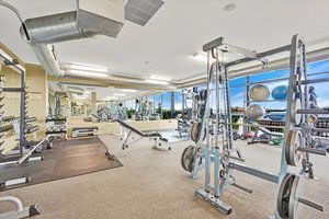Indoor gym area with various fitness equipment and weights.