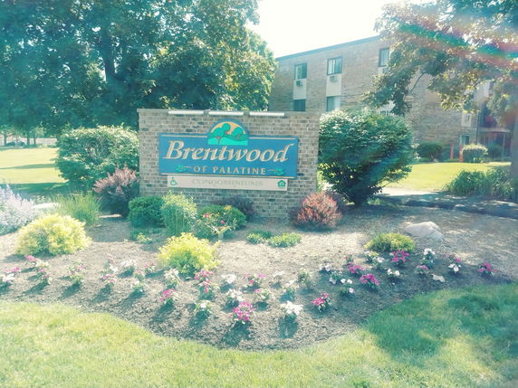 Front view of a three-story brick condominium building.