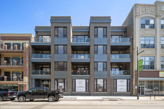 Front view of a modern multi-story building with balconies.
