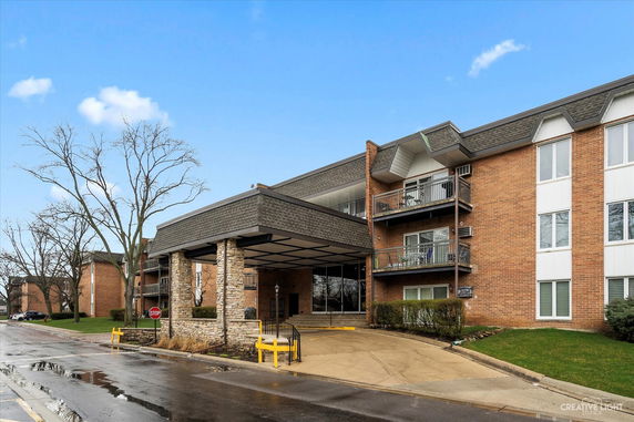 Front view of a multi-story building with brick facade and balconies.